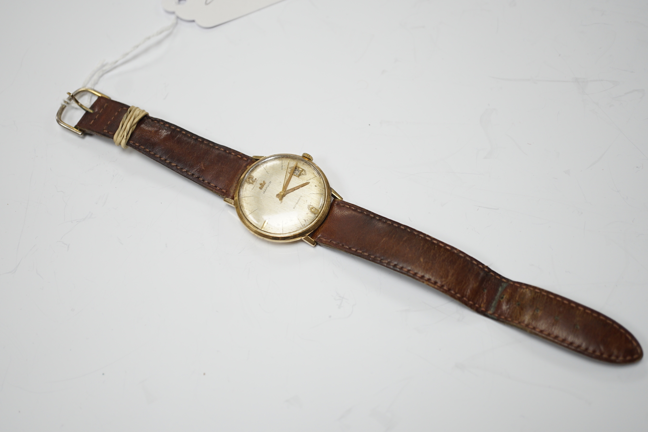 A gentleman's 9ct gold Marvin automatic wrist watch, with date aperture, on a leather strap.